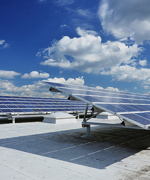 Commercial rooftop solar panel array under blue sky, flat roof PV installation by Solavita