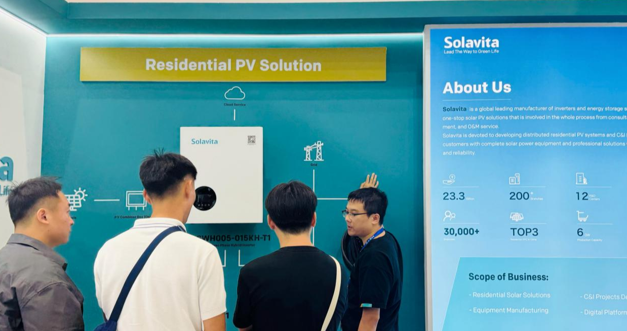 Solavita staff explaining residential PV solution with hybrid inverter to visitors at a solar energy exhibition booth