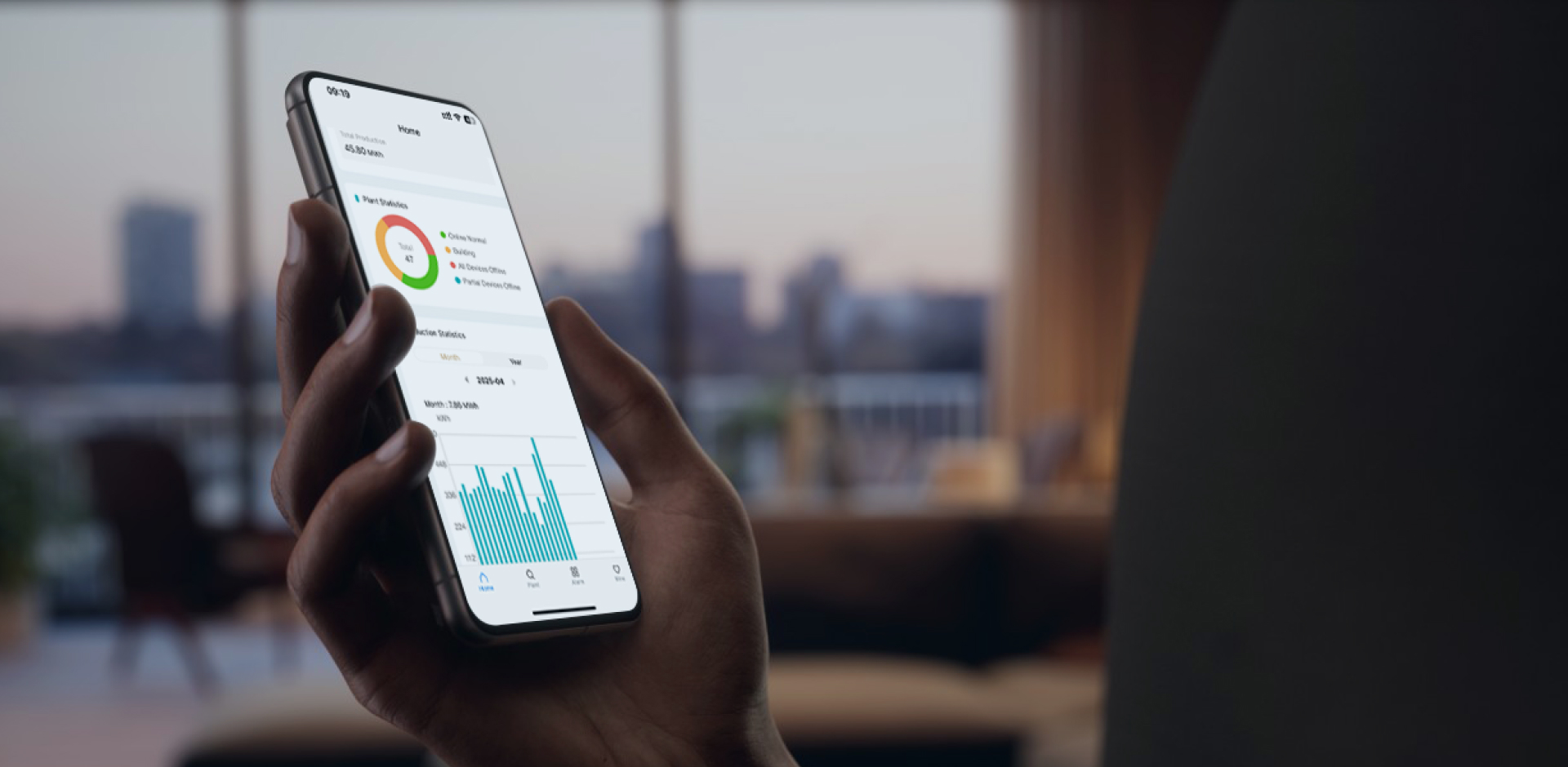 Hand holding smartphone showing Solavita Cloud app with solar plant status and energy statistics in a cozy indoor environment
