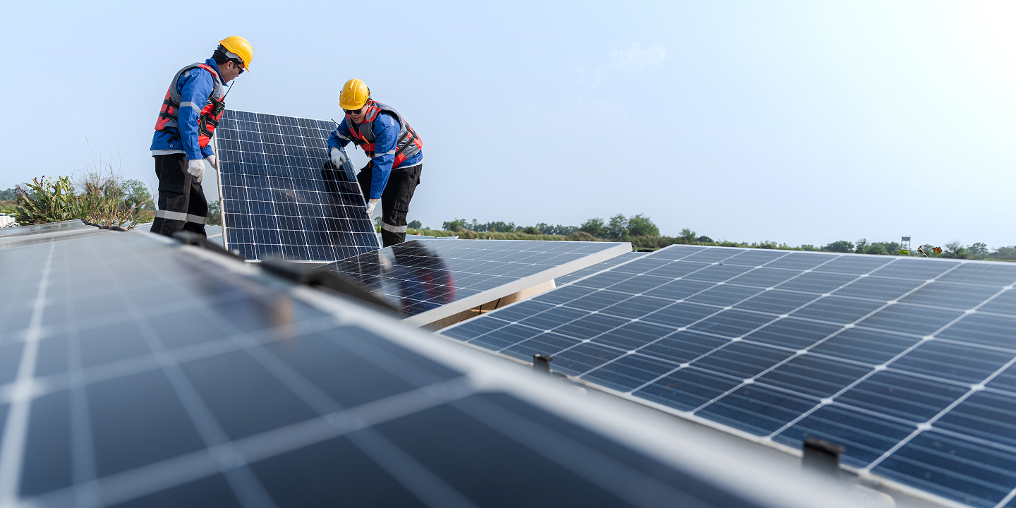 Solavita EPC team installing solar panels on a commercial rooftop under clear sky