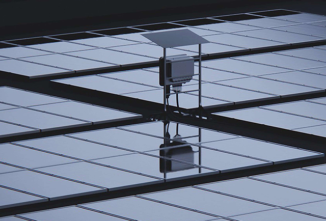 Microinverter mounted above solar panels with integrated cable connections and protective canopy.